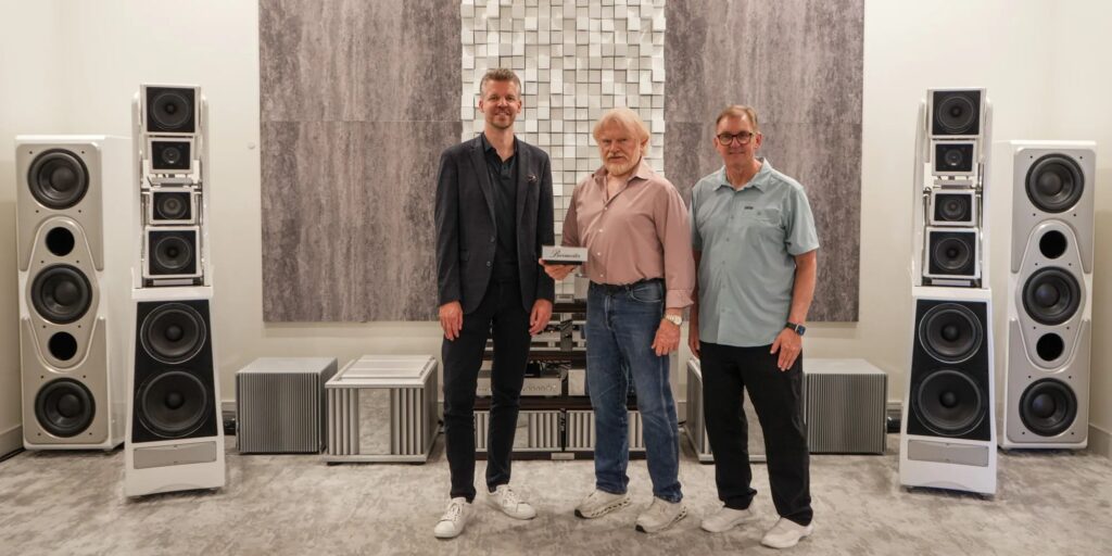 Matthias Prange of Burmester, LMC President and Co-Founder Mike Ware holding the Burmester Dealer of the Year award, and Norm Steinke of Burmester in the LMC Scottsdale reference room
